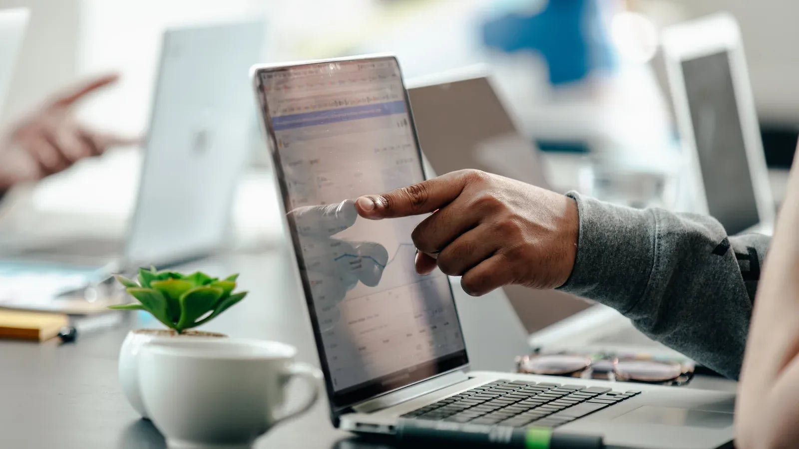 Colleague pointing to analytics data on a laptop during a review.