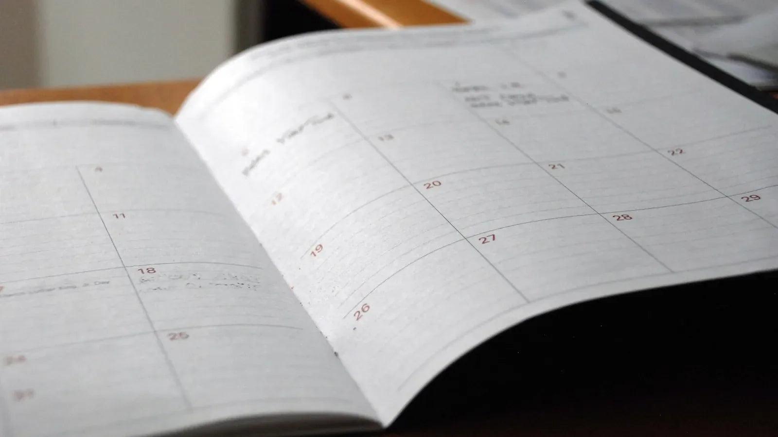 Open monthly planner on wooden desk.