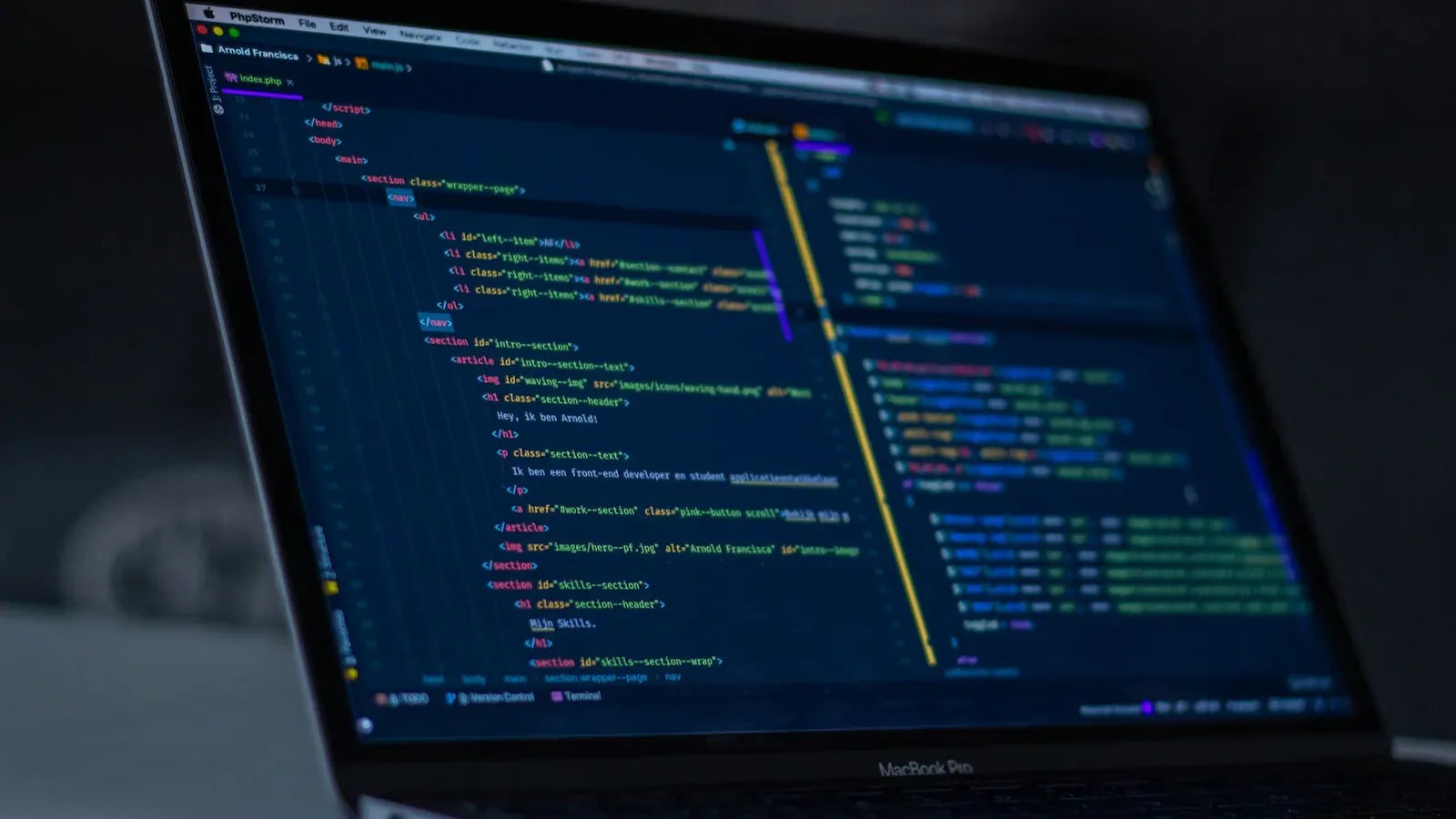 Turned-on MacBook Pro with programming codes display.